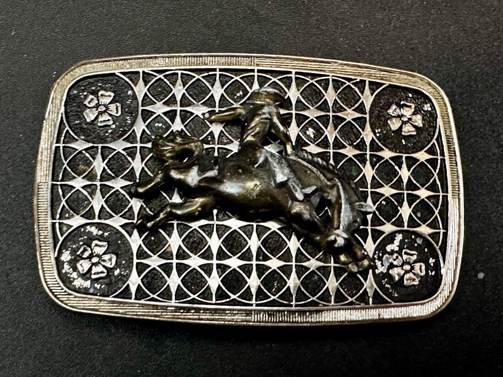 Vintage Cowboy on Saddle Bronc Western belt buckle with mesh pattern background