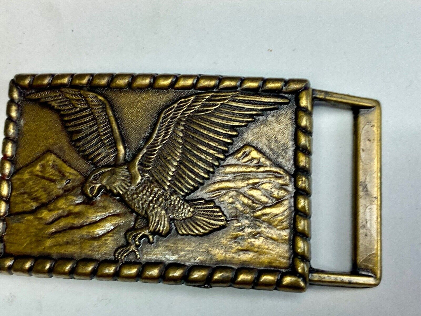 Vintage flying, hunting, fishing American eagle belt buckle with western boarder