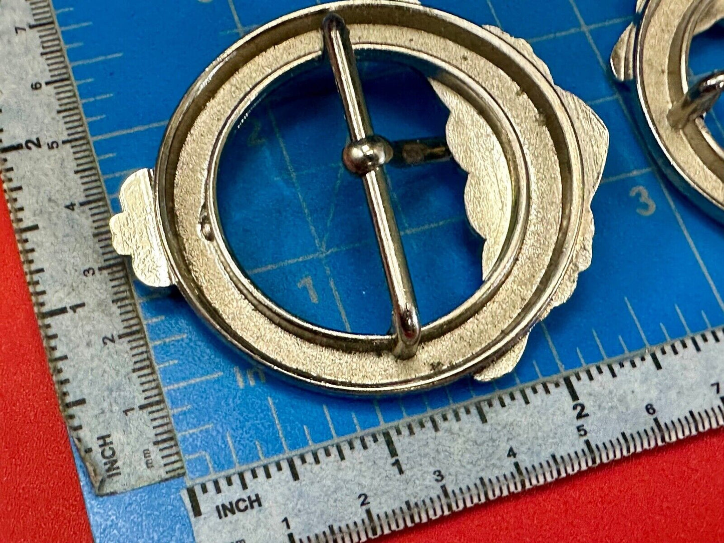 Two Kathy Van Zeeland signed silver tone round heart accented belt buckles