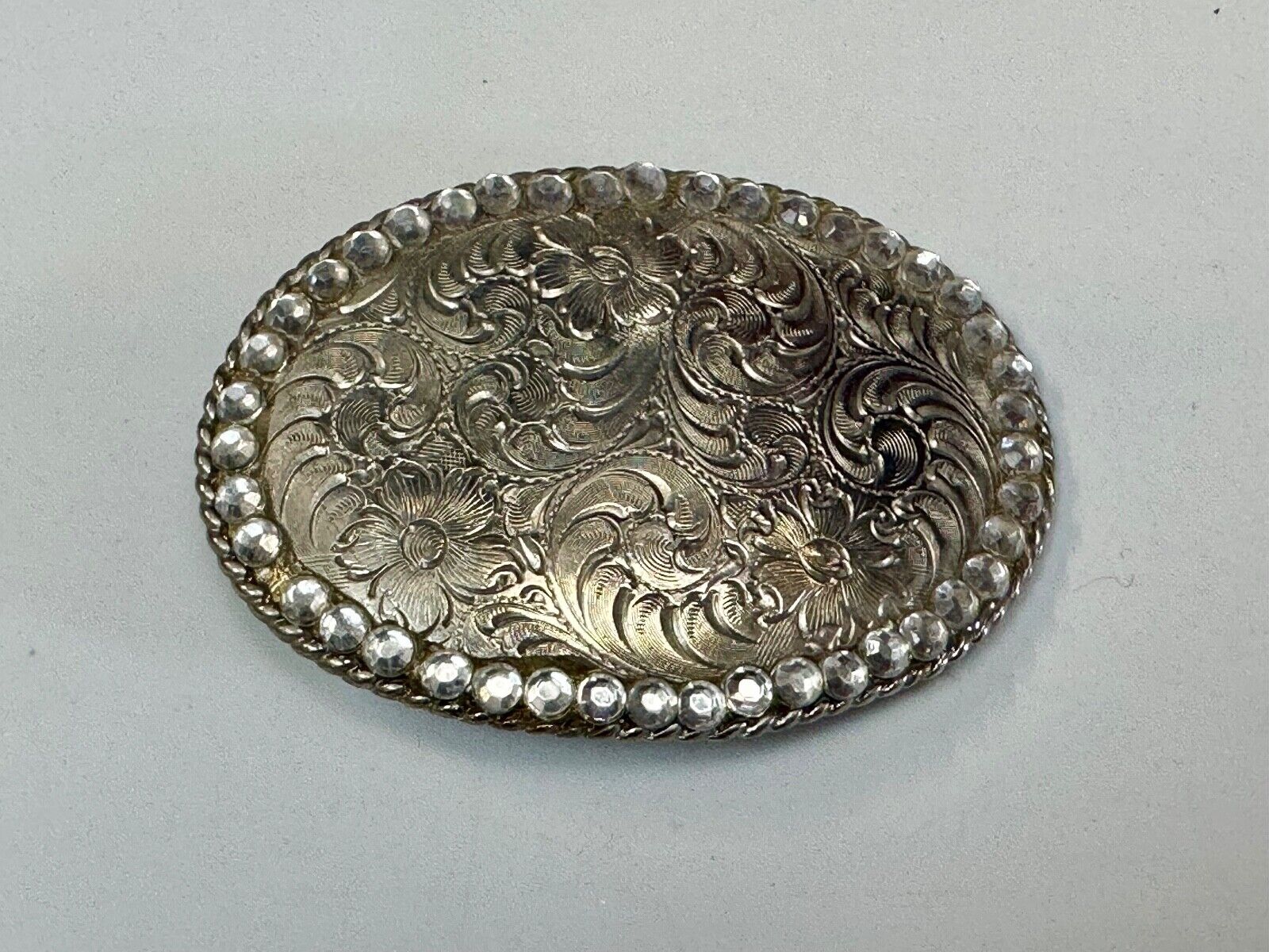 vintage 1996 western flower swirl oval belt buckle with rhinestone boarder