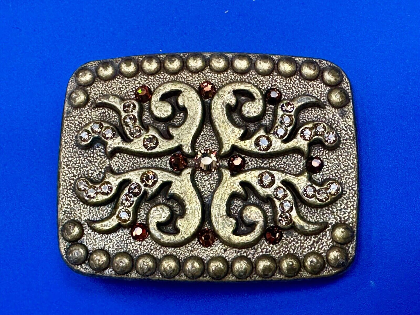 unique rhinestone accented swirl pattern on rounded rectangular belt buckle