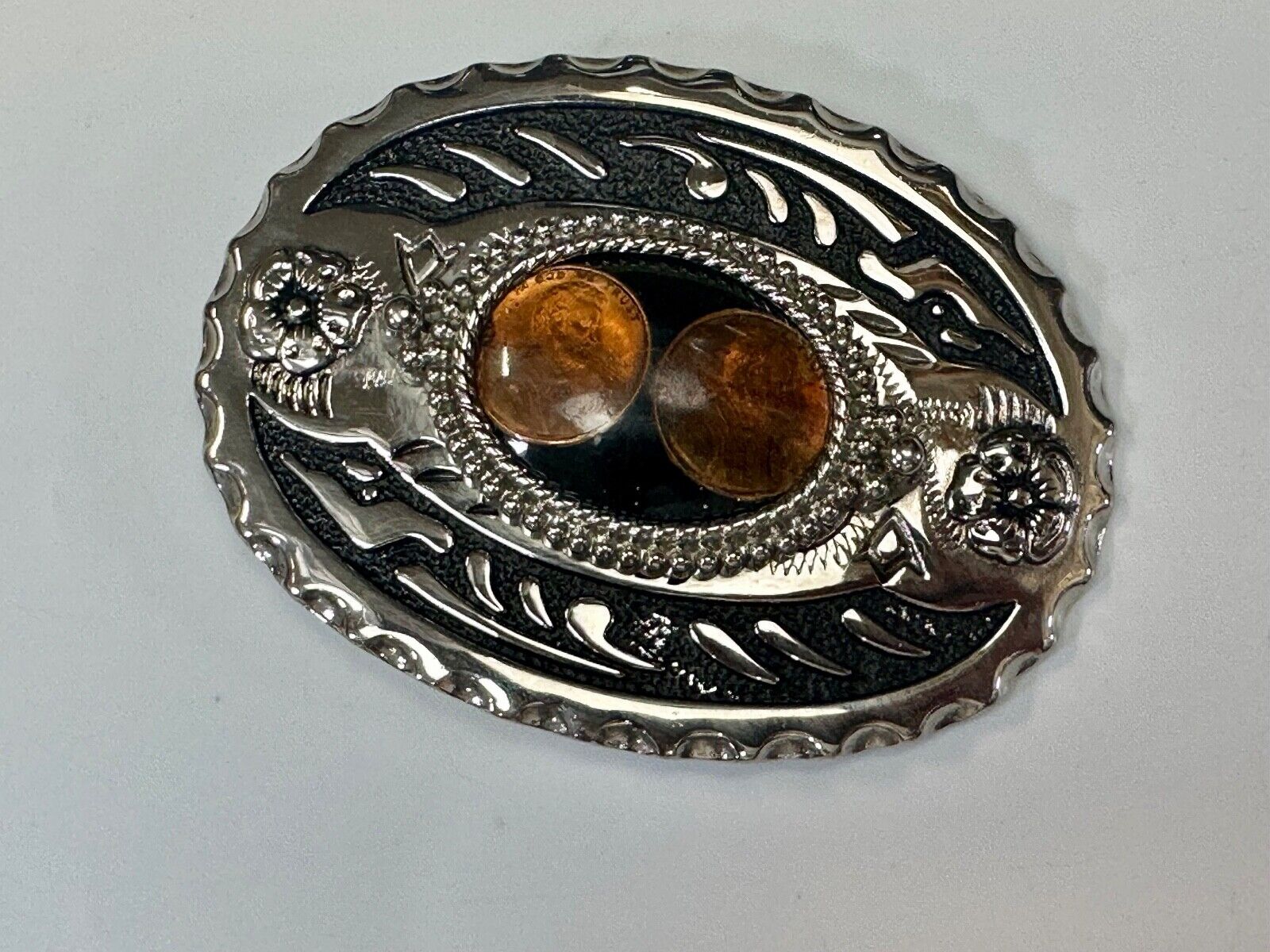 Two lucky pennies coins encased in cab style centerpiece of western belt buckle