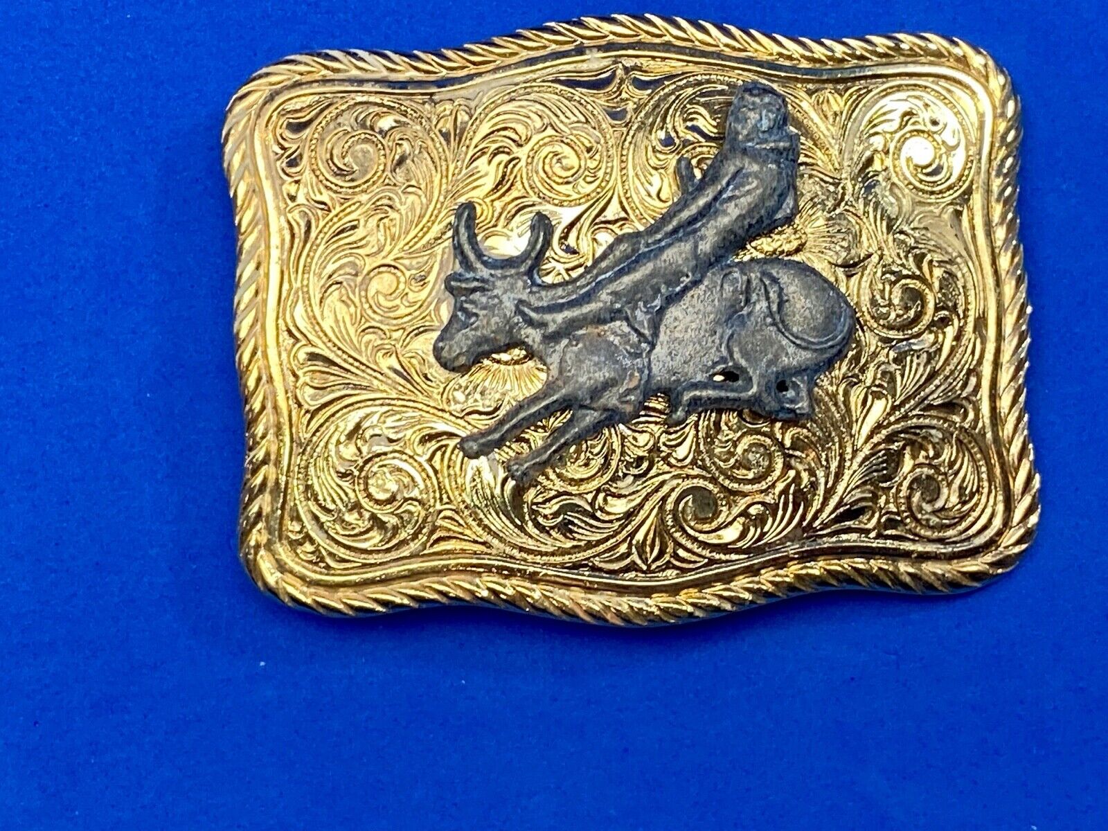 bull riding rodeo cowboy on beautiful gold color flower swirl belt buckle 