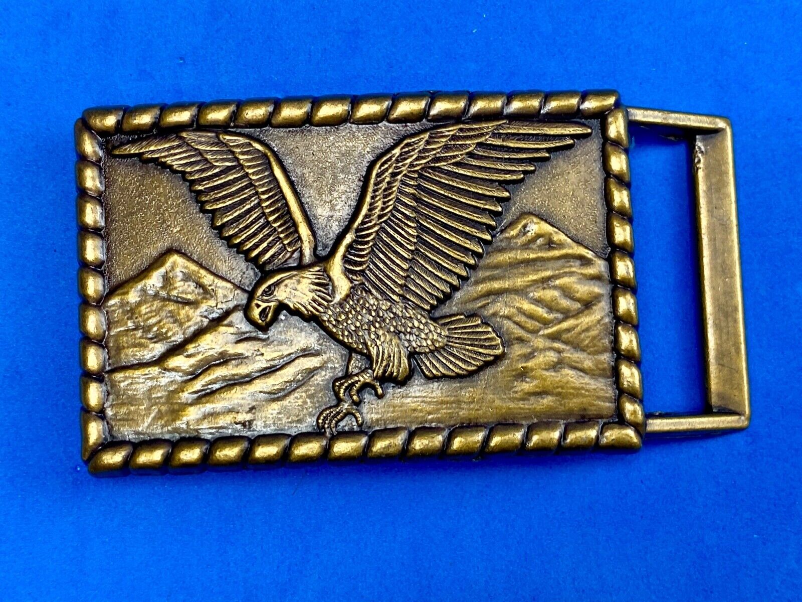Vintage flying, hunting, fishing American eagle belt buckle with western boarder