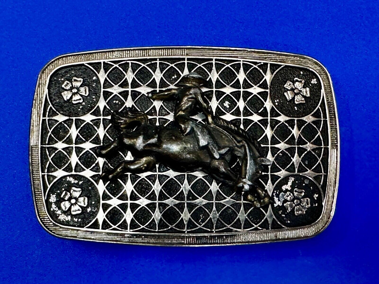 Vintage Cowboy on Saddle Bronc Western belt buckle with mesh pattern background