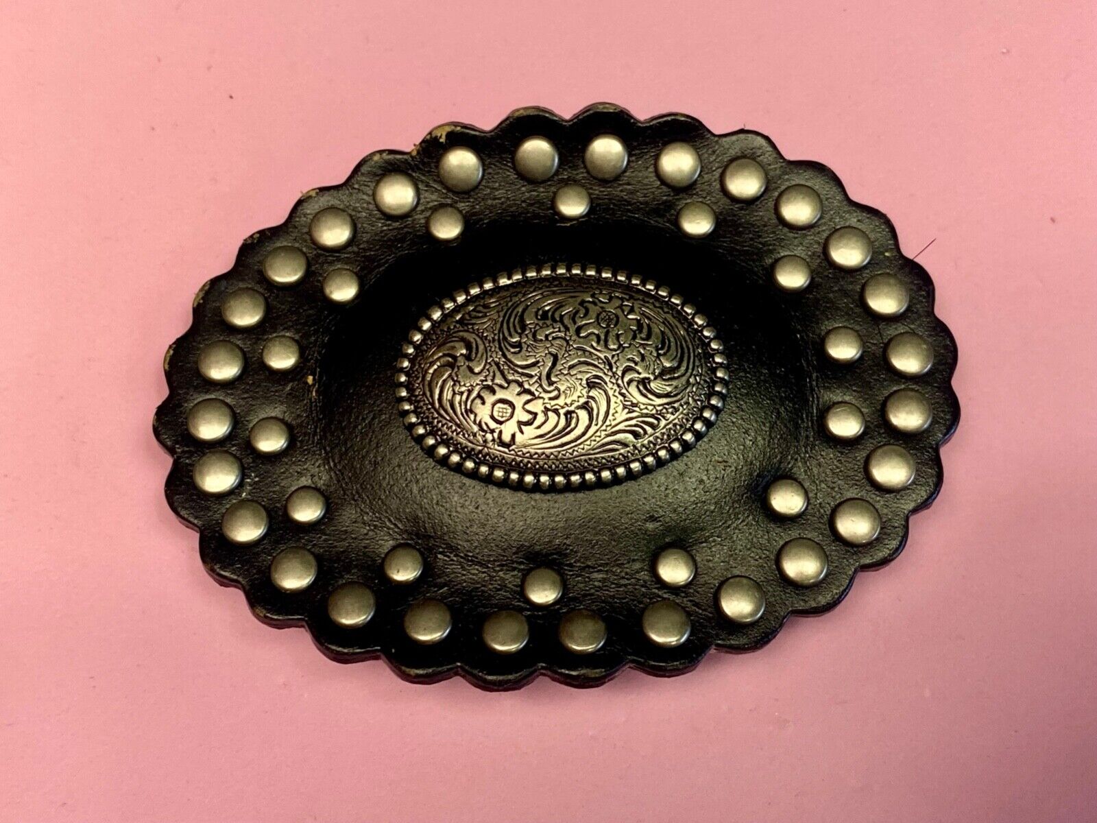 4" wide studded black leather oval belt buckle with flower swirl center