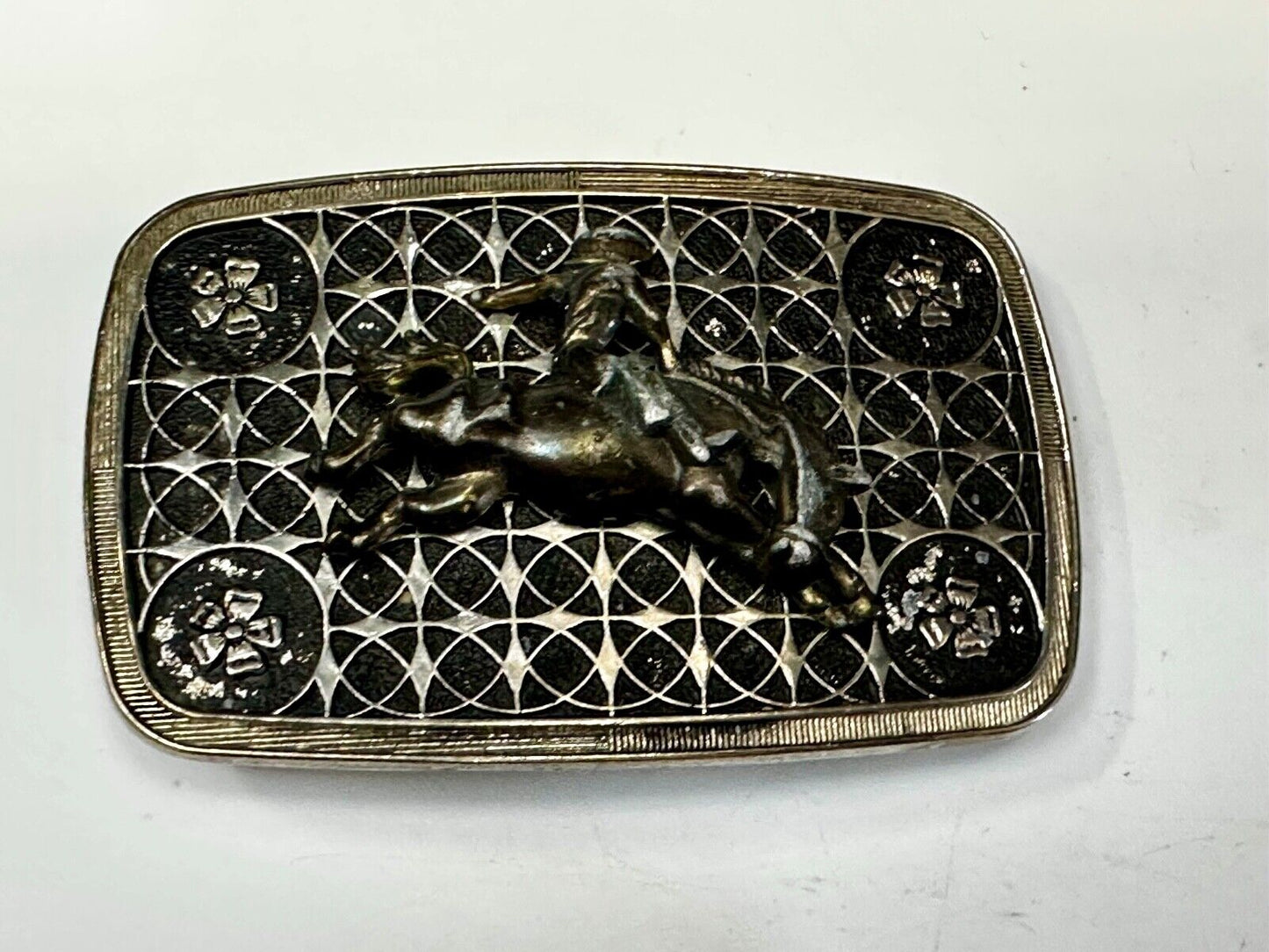 Vintage Cowboy on Saddle Bronc Western belt buckle with mesh pattern background