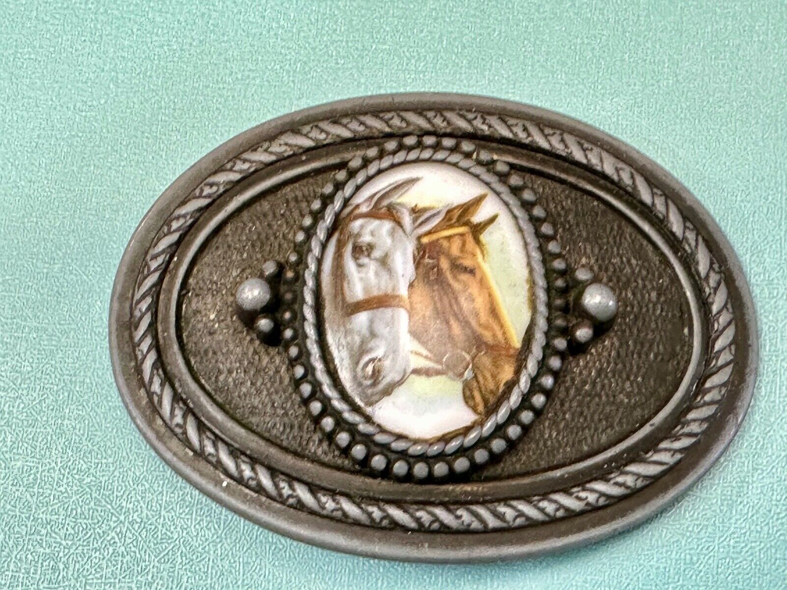 2 horses picture as centerpiece in western oval belt buckle with rope border