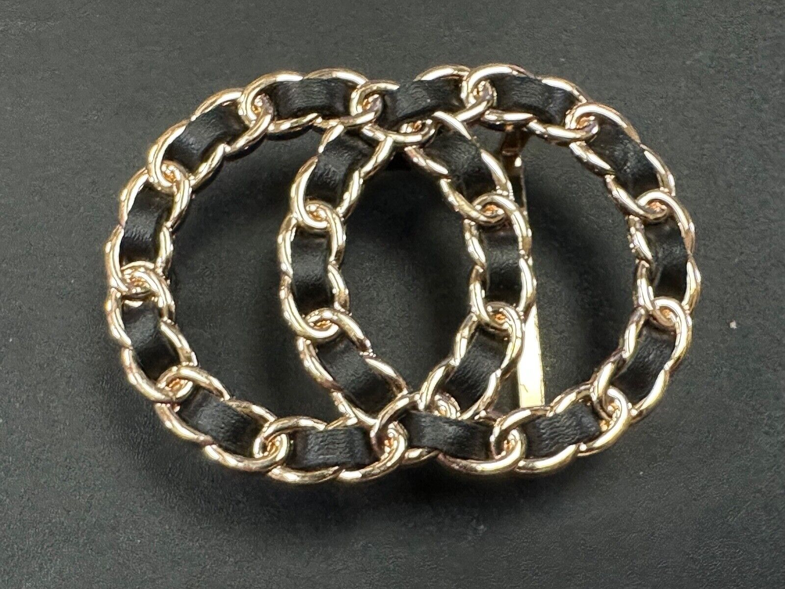Two gold tone Overlapping Circle's with black ribbon through-out belt buckle