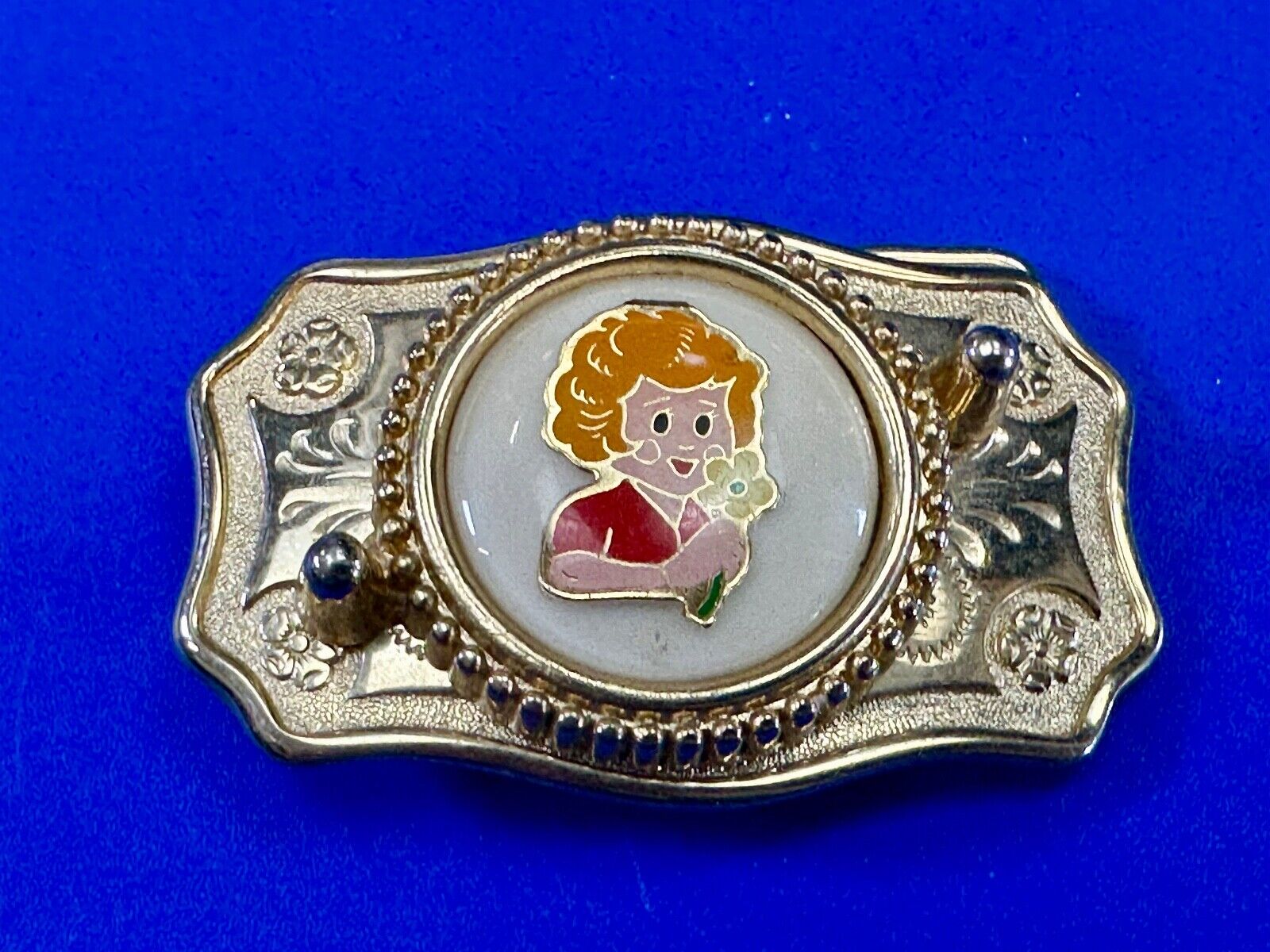 Adorable red headed girl with flower as centerpiece on western belt buckle