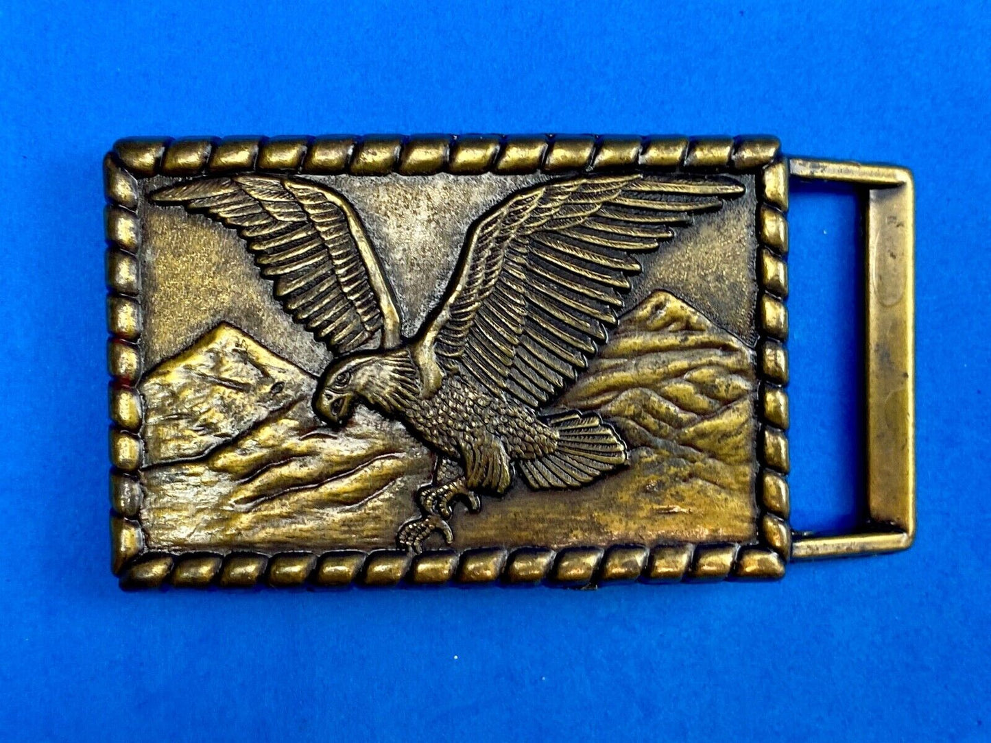 Vintage flying, hunting, fishing American eagle belt buckle with western boarder