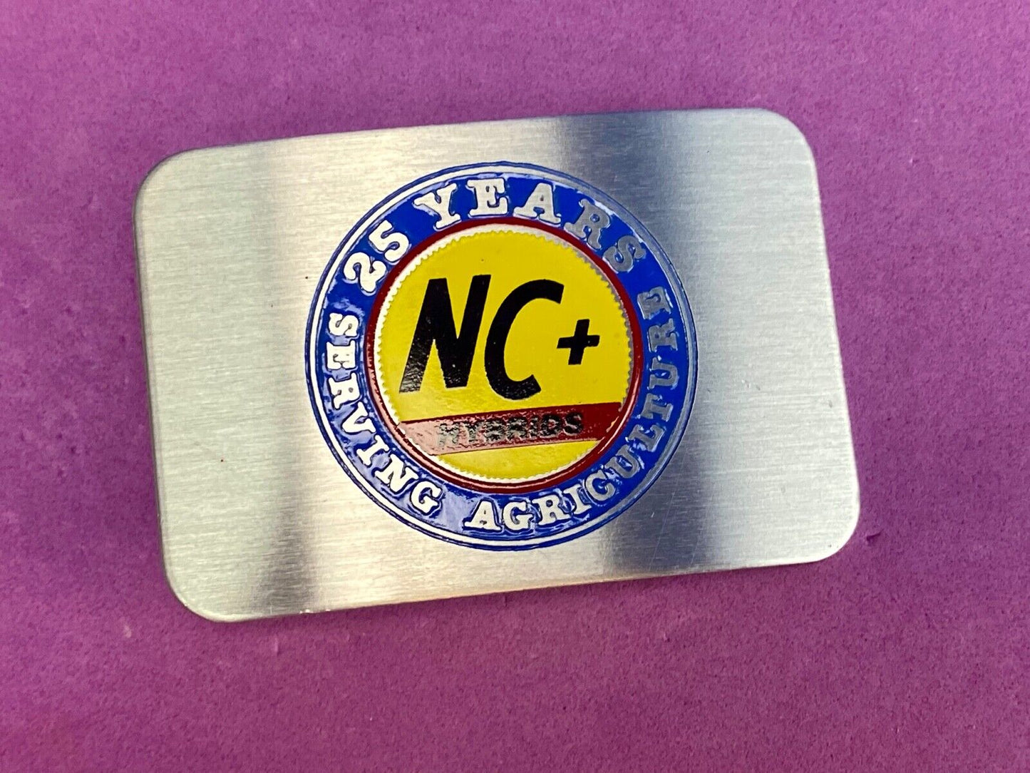 25 years serving agriculture - NC+ Hybrids belt buckle