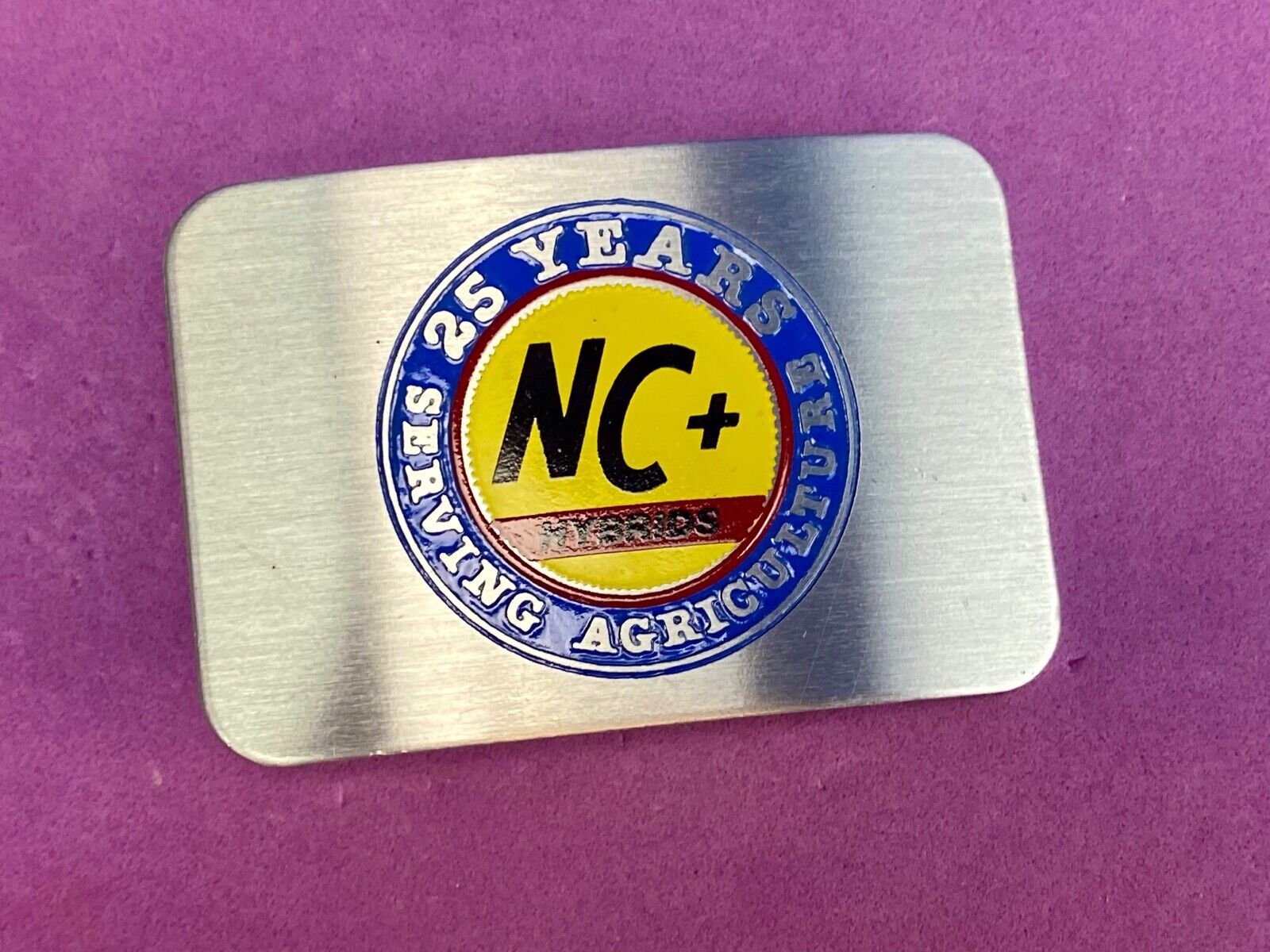 25 years serving agriculture - NC+ Hybrids belt buckle
