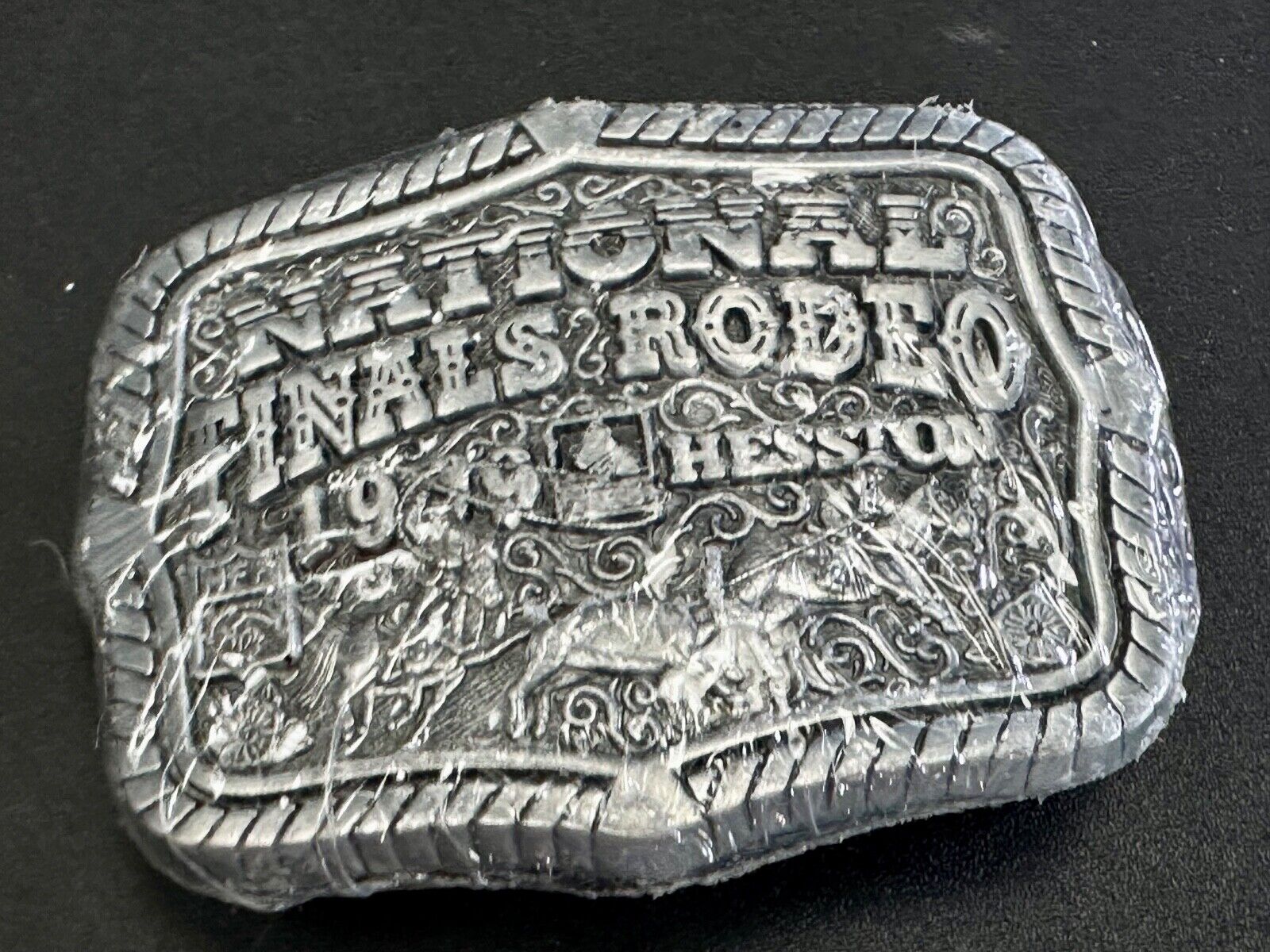1999 Youth Sized Hesston National Finals Rodeo 2000 series belt buckle in wrap
