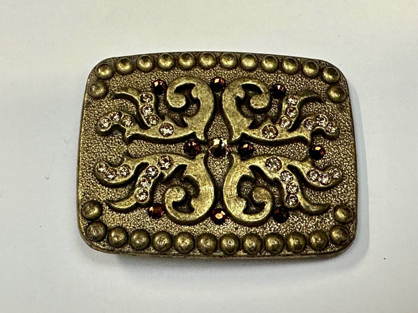 unique rhinestone accented swirl pattern on rounded rectangular belt buckle