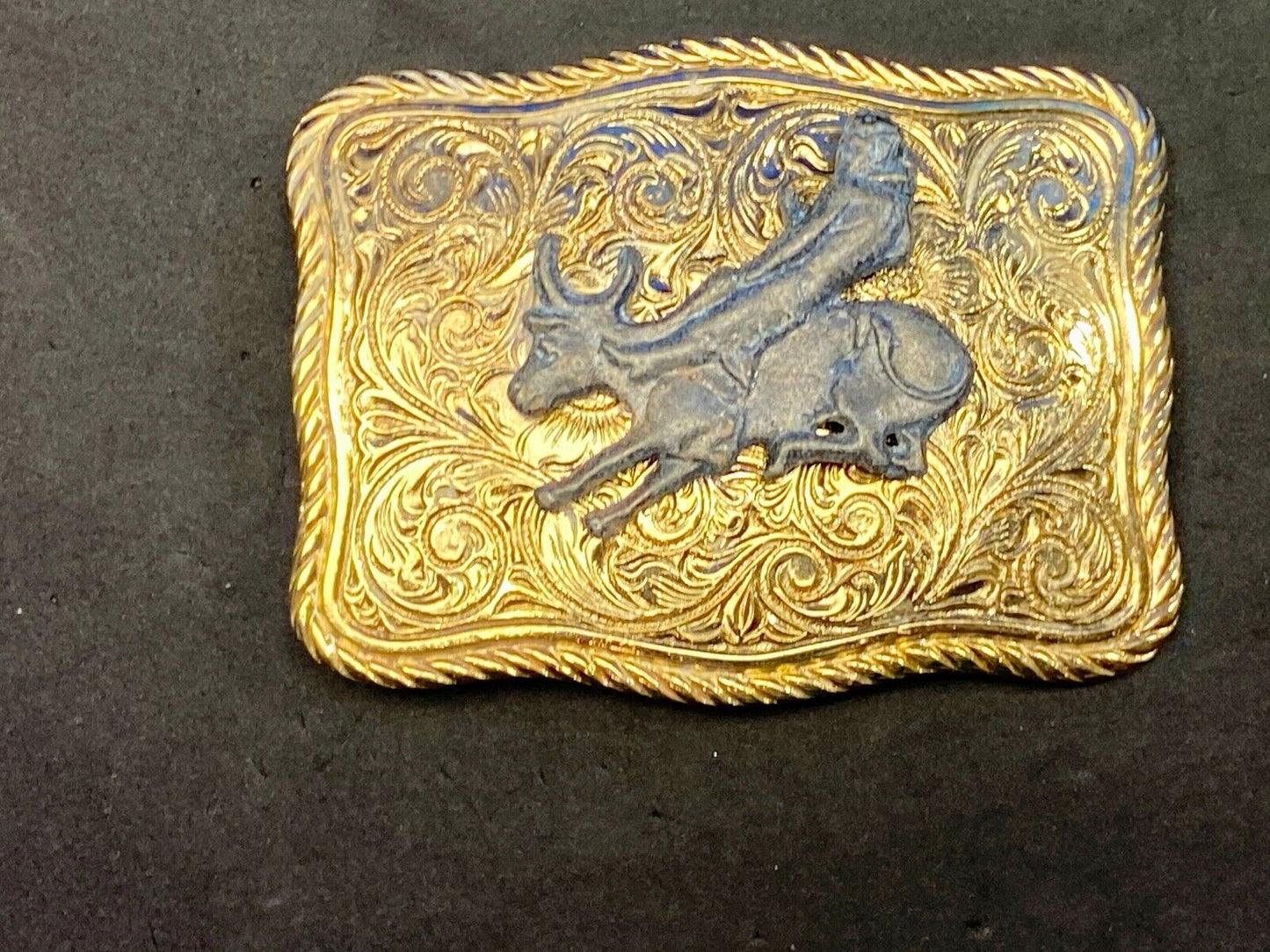 bull riding rodeo cowboy on beautiful gold color flower swirl belt buckle 