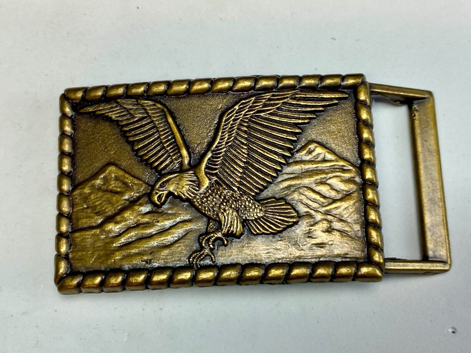 Vintage flying, hunting, fishing American eagle belt buckle with western boarder