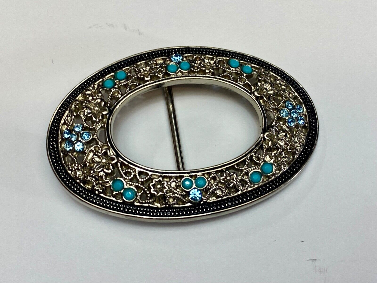 Unique blue rhinestone accented oval see though silver tone belt buckle