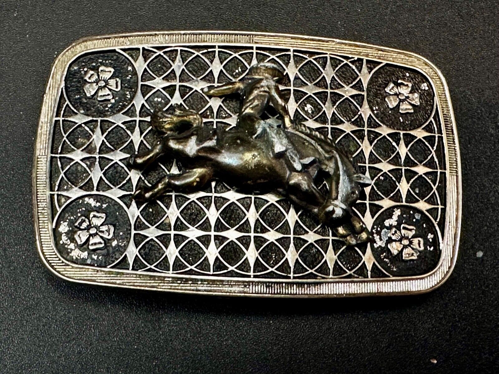 Vintage Cowboy on Saddle Bronc Western belt buckle with mesh pattern background