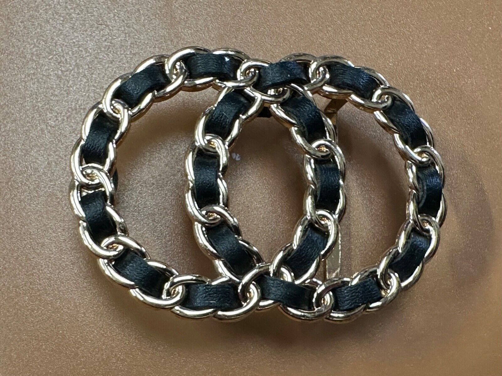Two gold tone Overlapping Circle's with black ribbon through-out belt buckle