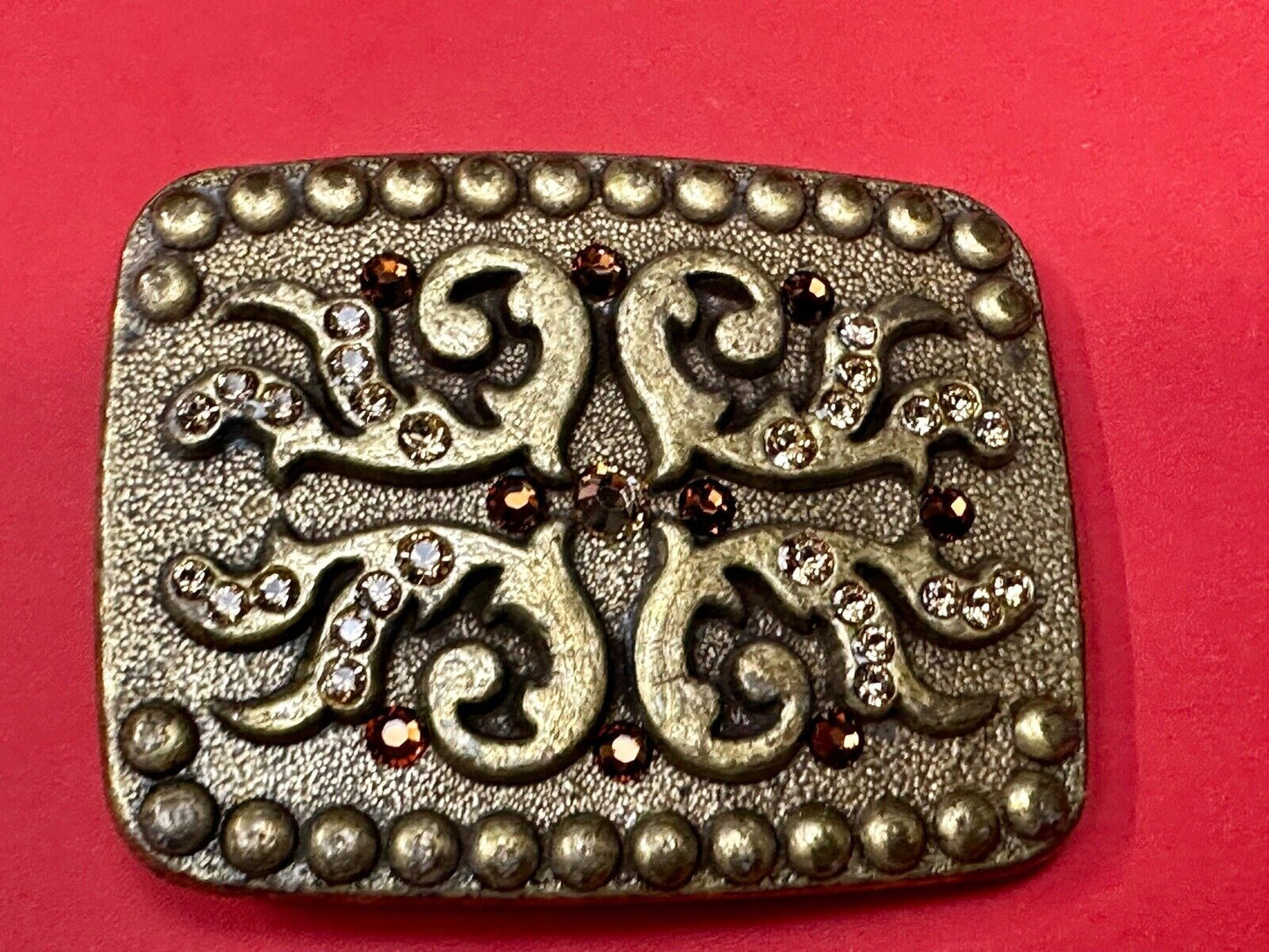unique rhinestone accented swirl pattern on rounded rectangular belt buckle