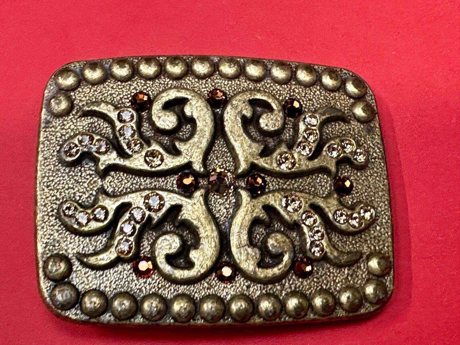 unique rhinestone accented swirl pattern on rounded rectangular belt buckle