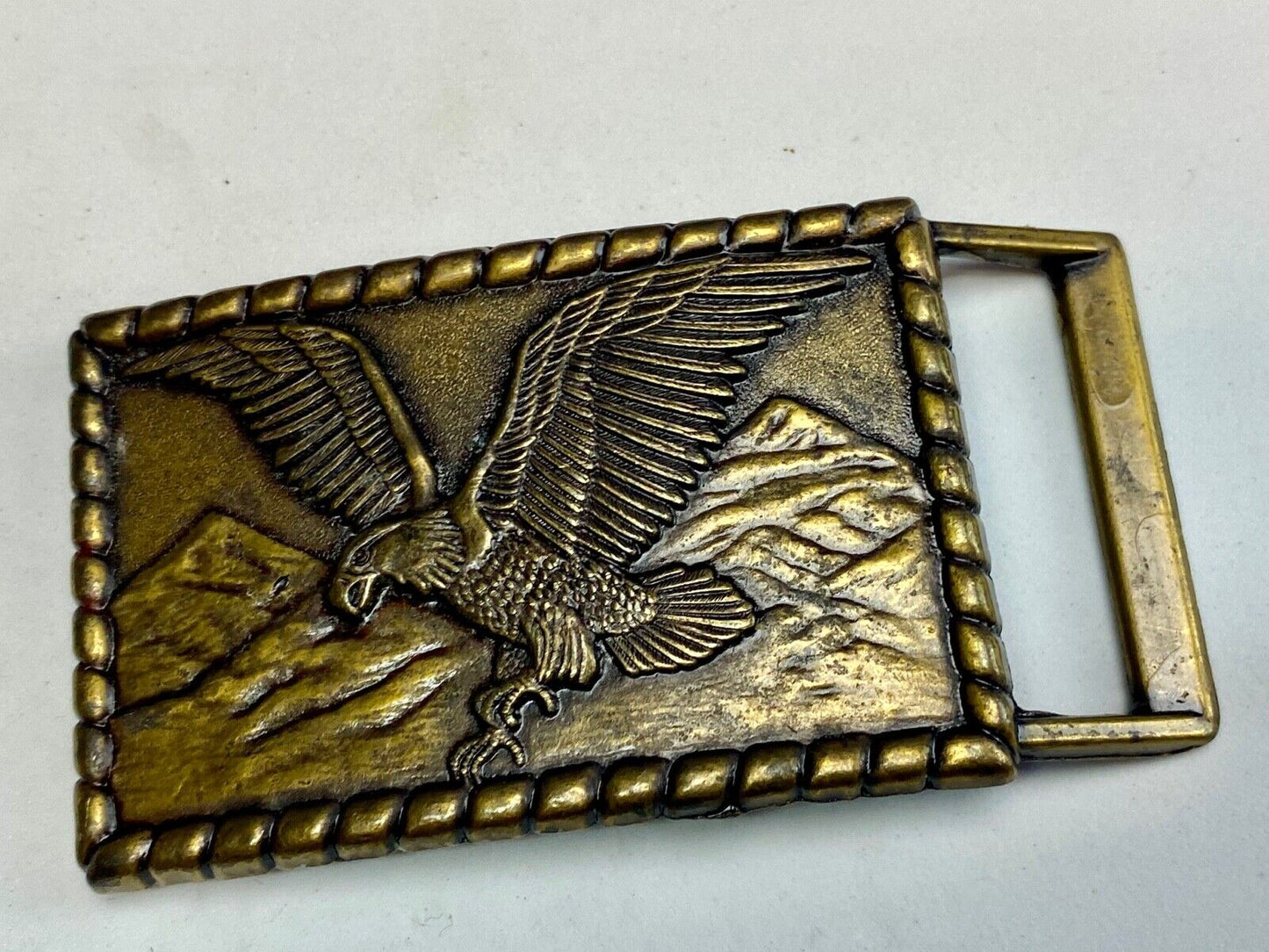 Vintage flying, hunting, fishing American eagle belt buckle with western boarder