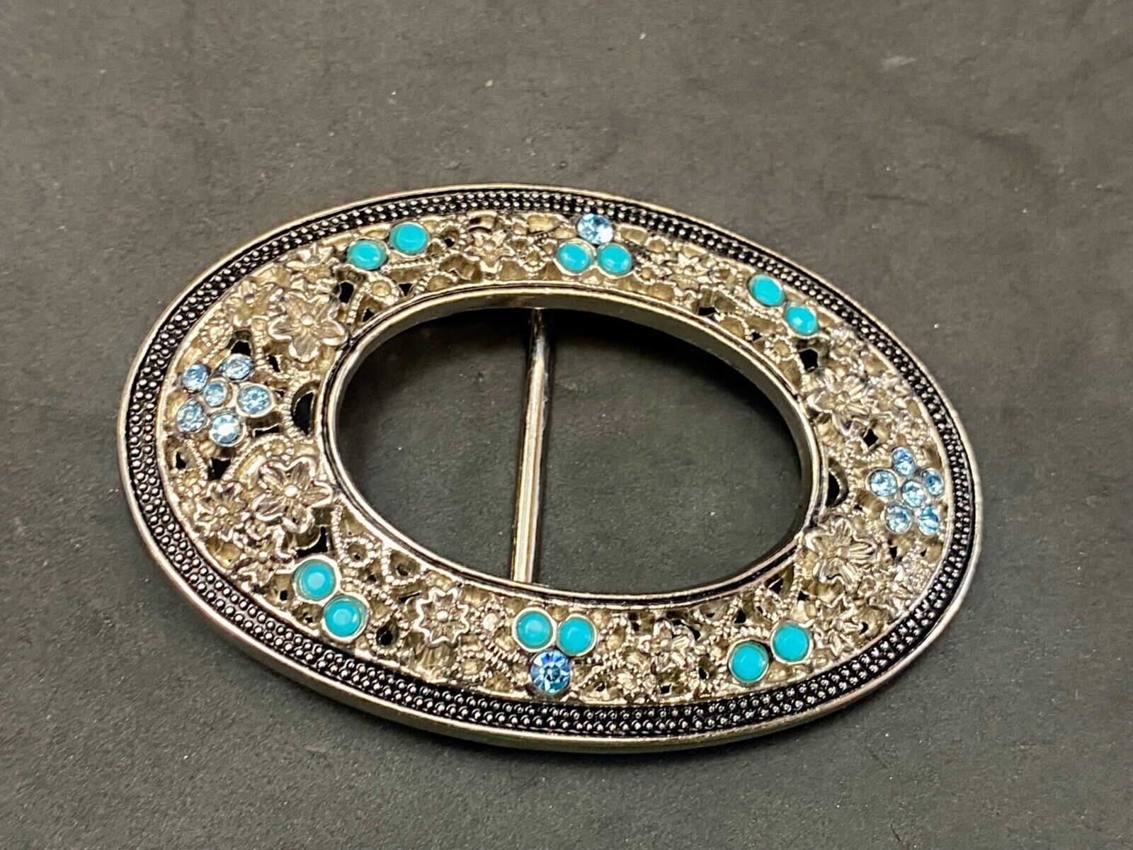 Unique blue rhinestone accented oval see though silver tone belt buckle