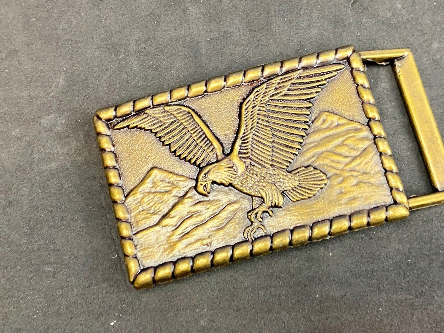 Vintage flying, hunting, fishing American eagle belt buckle with western boarder