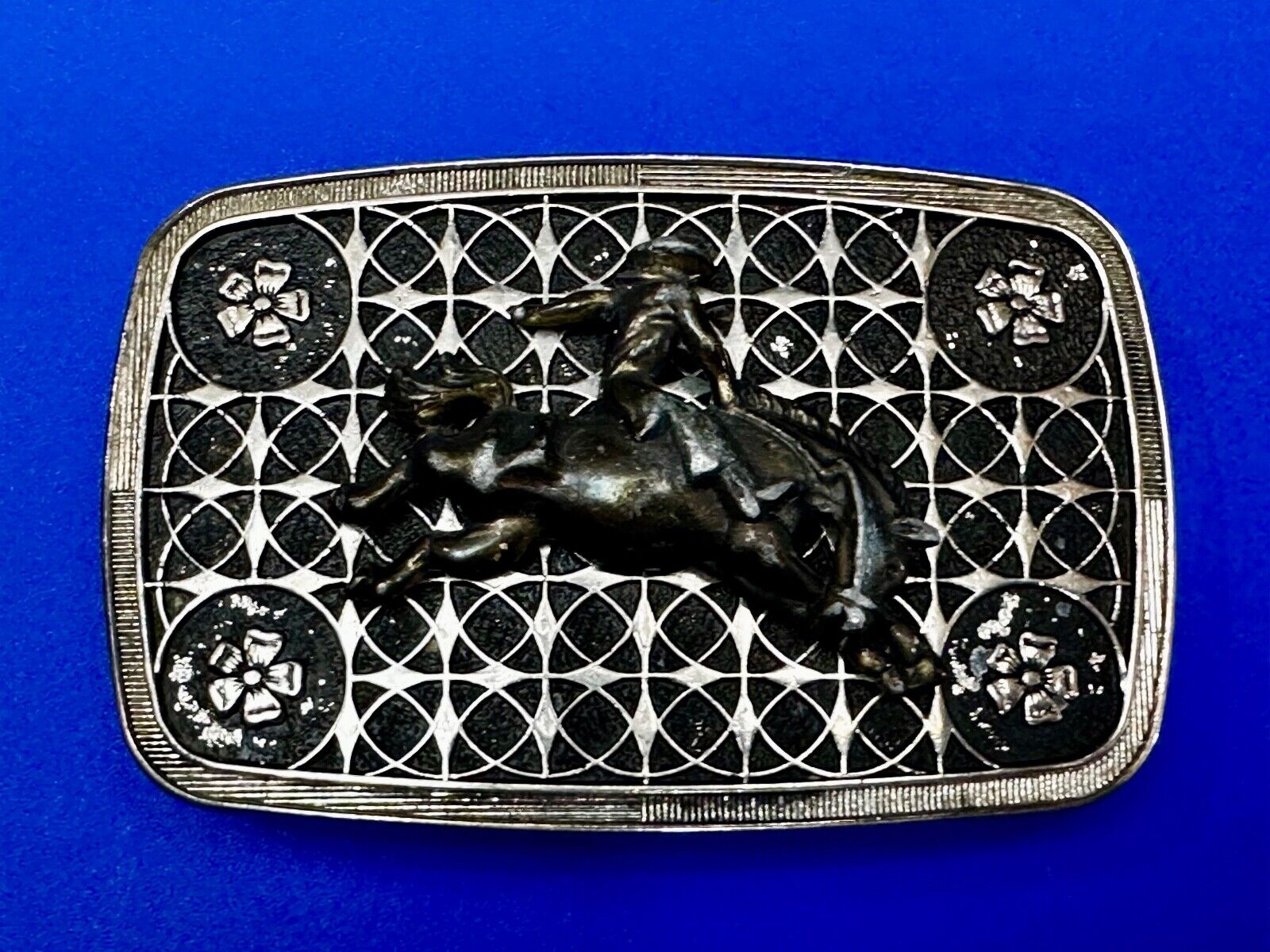 Vintage Cowboy on Saddle Bronc Western belt buckle with mesh pattern background
