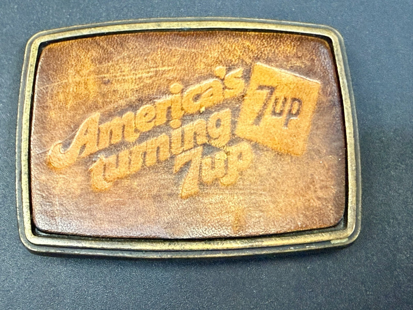 America's Turning 7up Embossed Leather on Metal Advertising Promo Belt Buckle