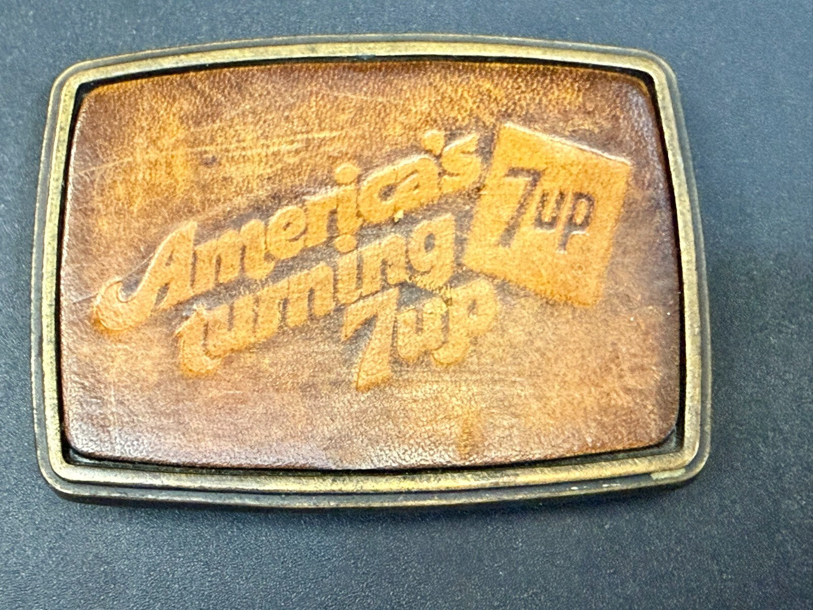America's Turning 7up Embossed Leather on Metal Advertising Promo Belt Buckle