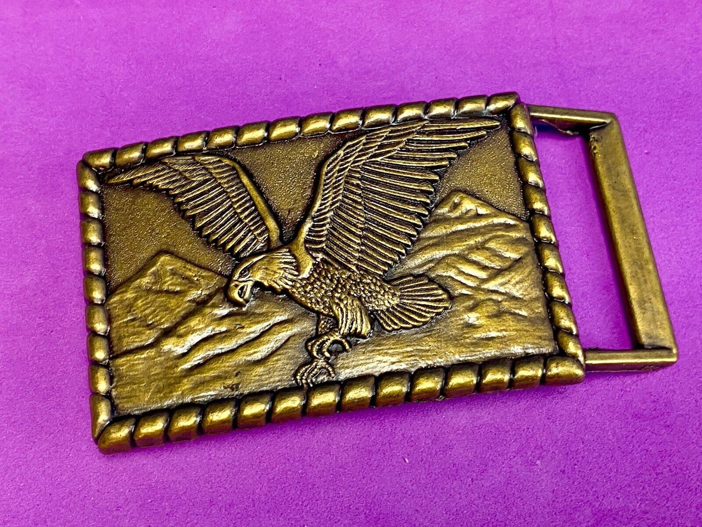 Vintage flying, hunting, fishing American eagle belt buckle with western boarder