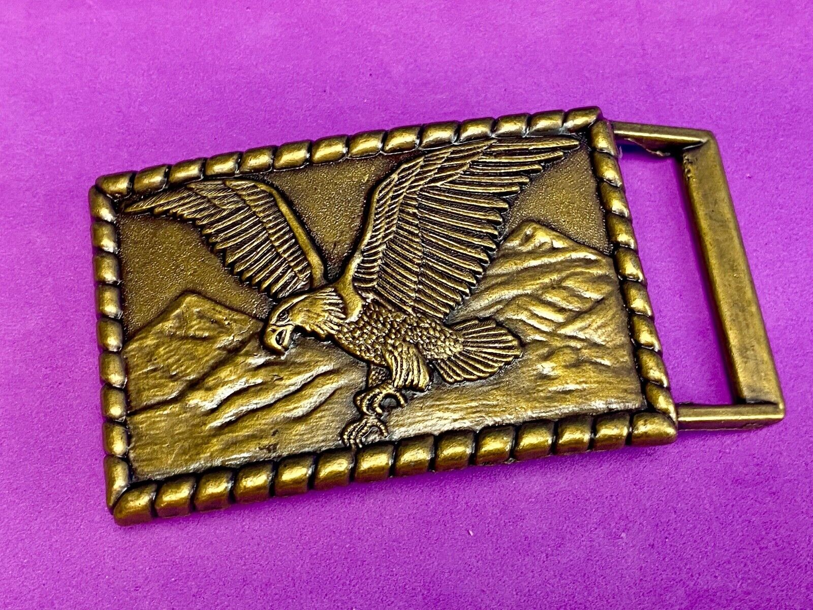 Vintage flying, hunting, fishing American eagle belt buckle with western boarder