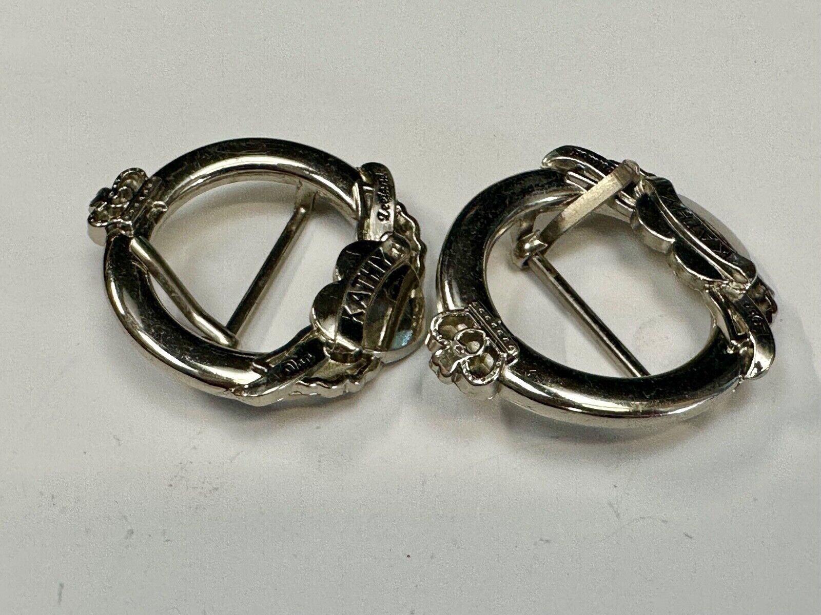 Two Kathy Van Zeeland signed silver tone round heart accented belt buckles