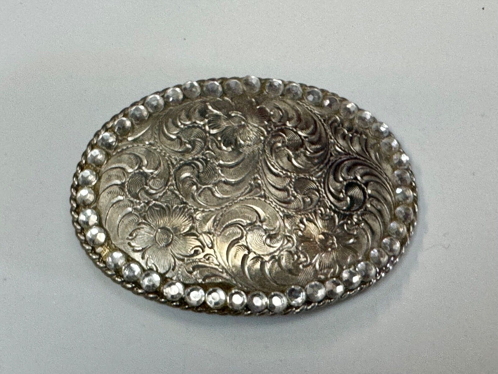 vintage 1996 western flower swirl oval belt buckle with rhinestone boarder
