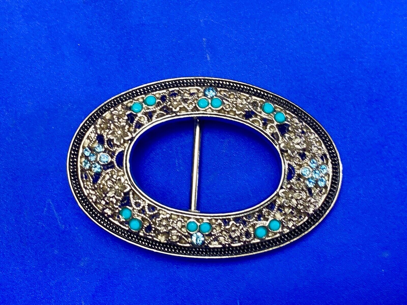 Unique blue rhinestone accented oval see though silver tone belt buckle