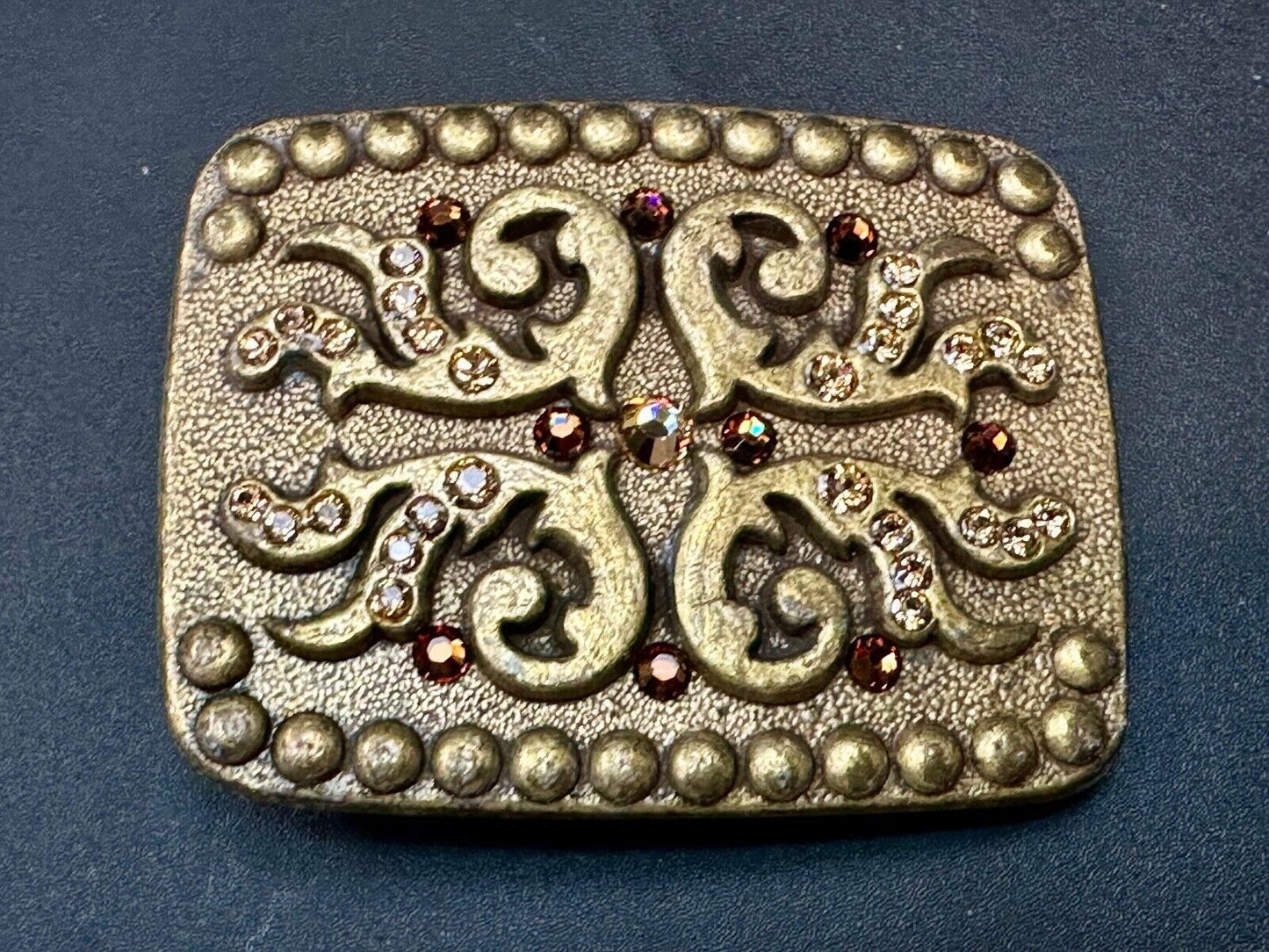 unique rhinestone accented swirl pattern on rounded rectangular belt buckle