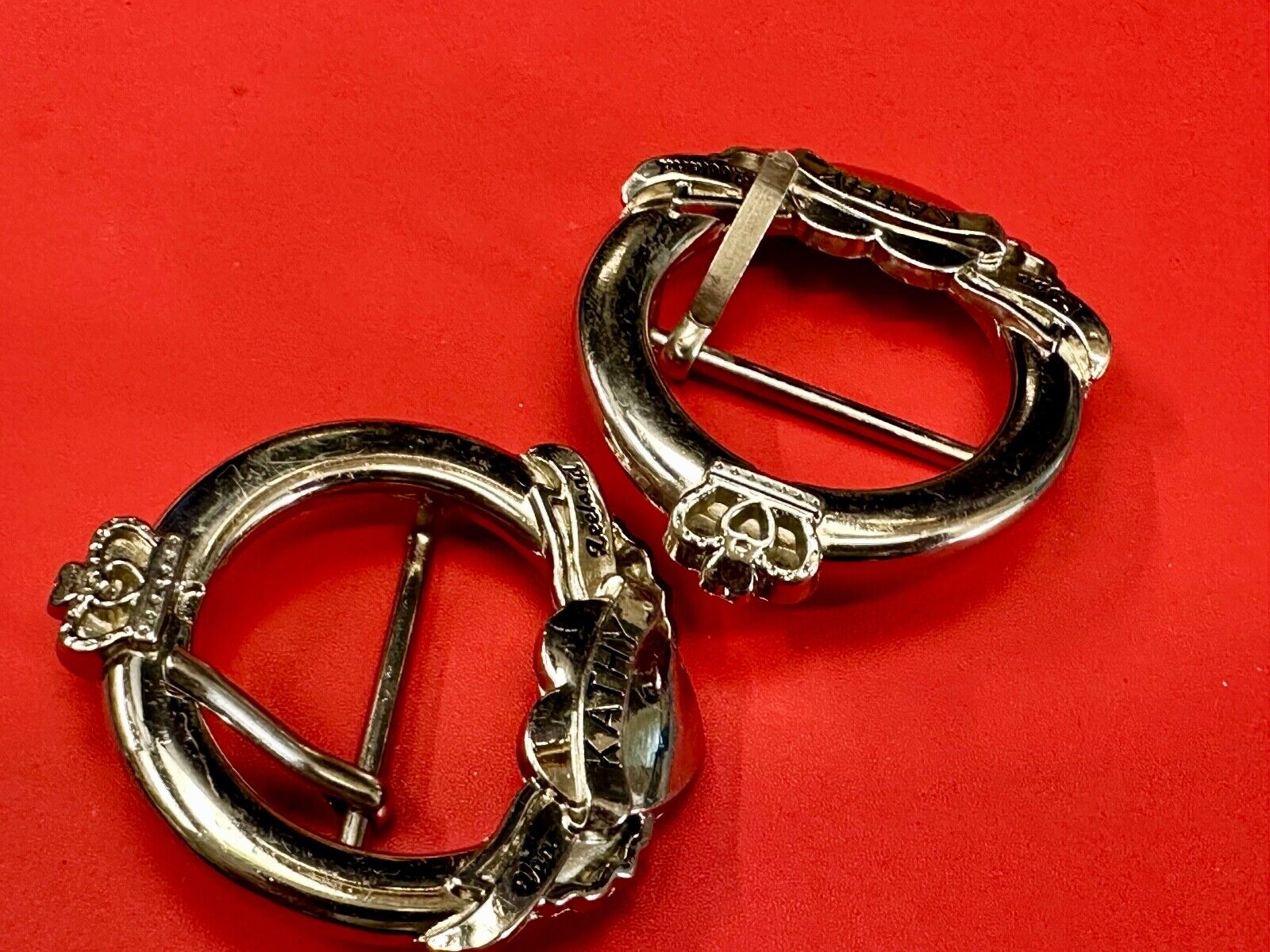 Two Kathy Van Zeeland signed silver tone round heart accented belt buckles