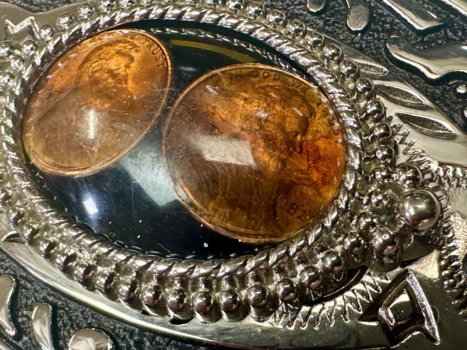 Two lucky pennies coins encased in cab style centerpiece of western belt buckle