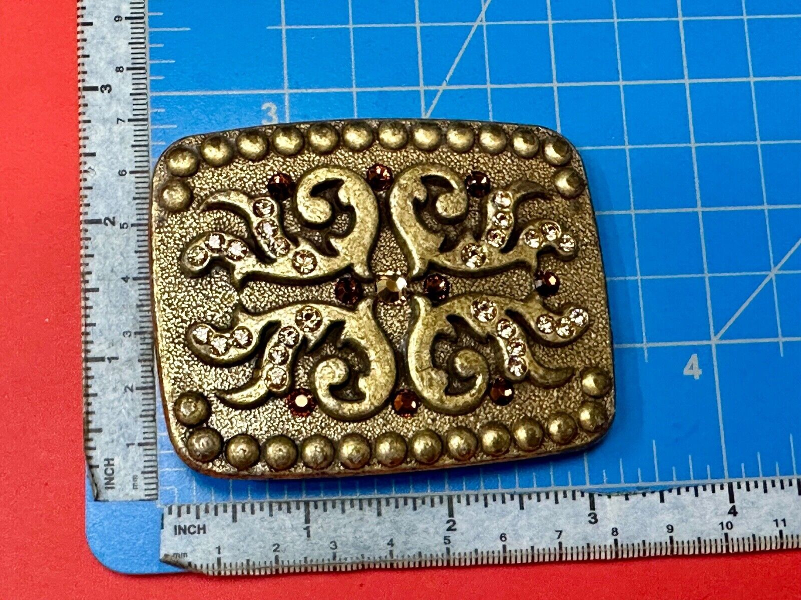 unique rhinestone accented swirl pattern on rounded rectangular belt buckle