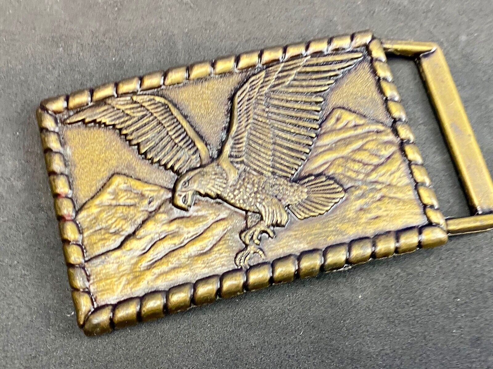 Vintage flying, hunting, fishing American eagle belt buckle with western boarder