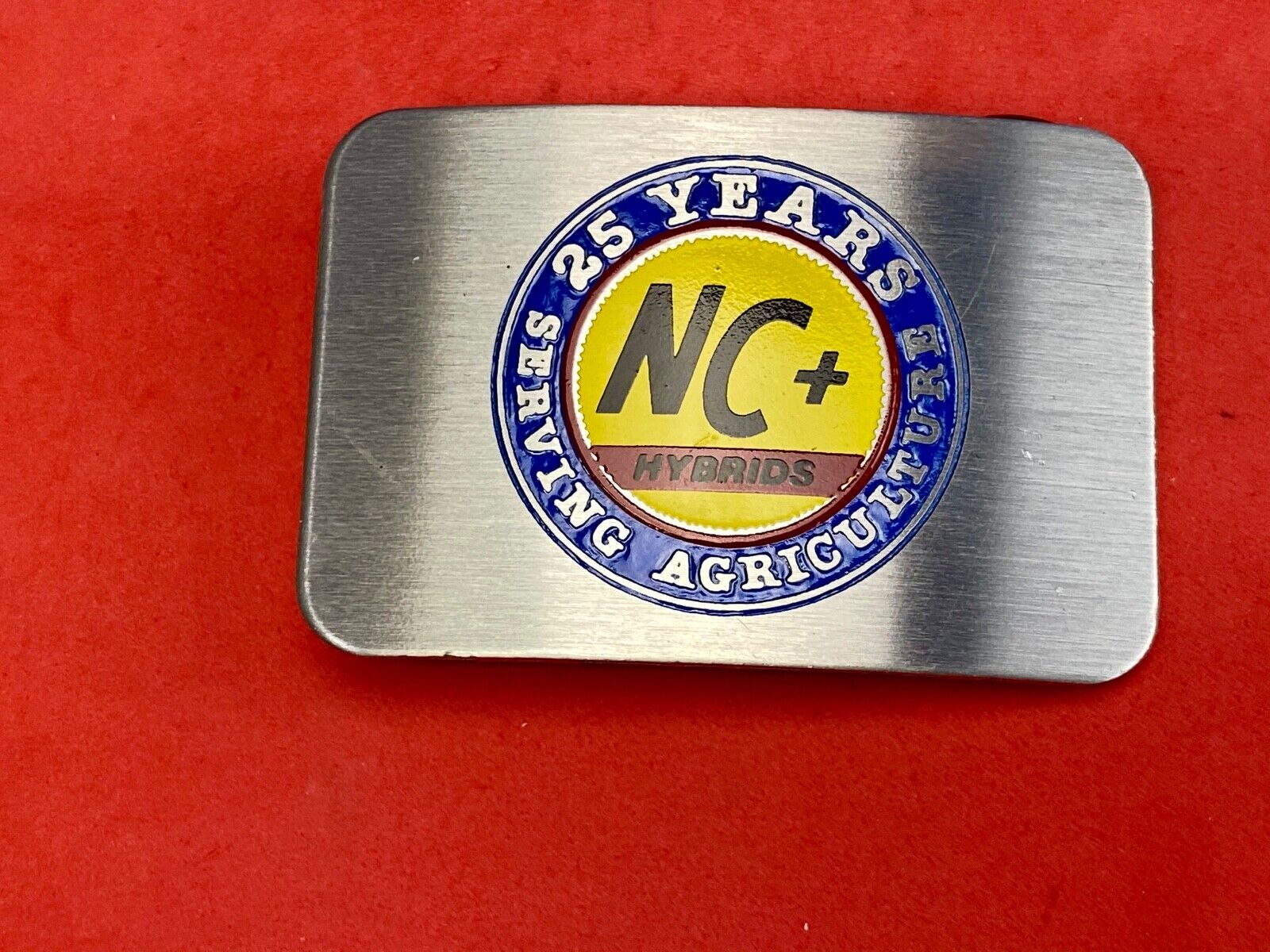 25 years serving agriculture - NC+ Hybrids belt buckle
