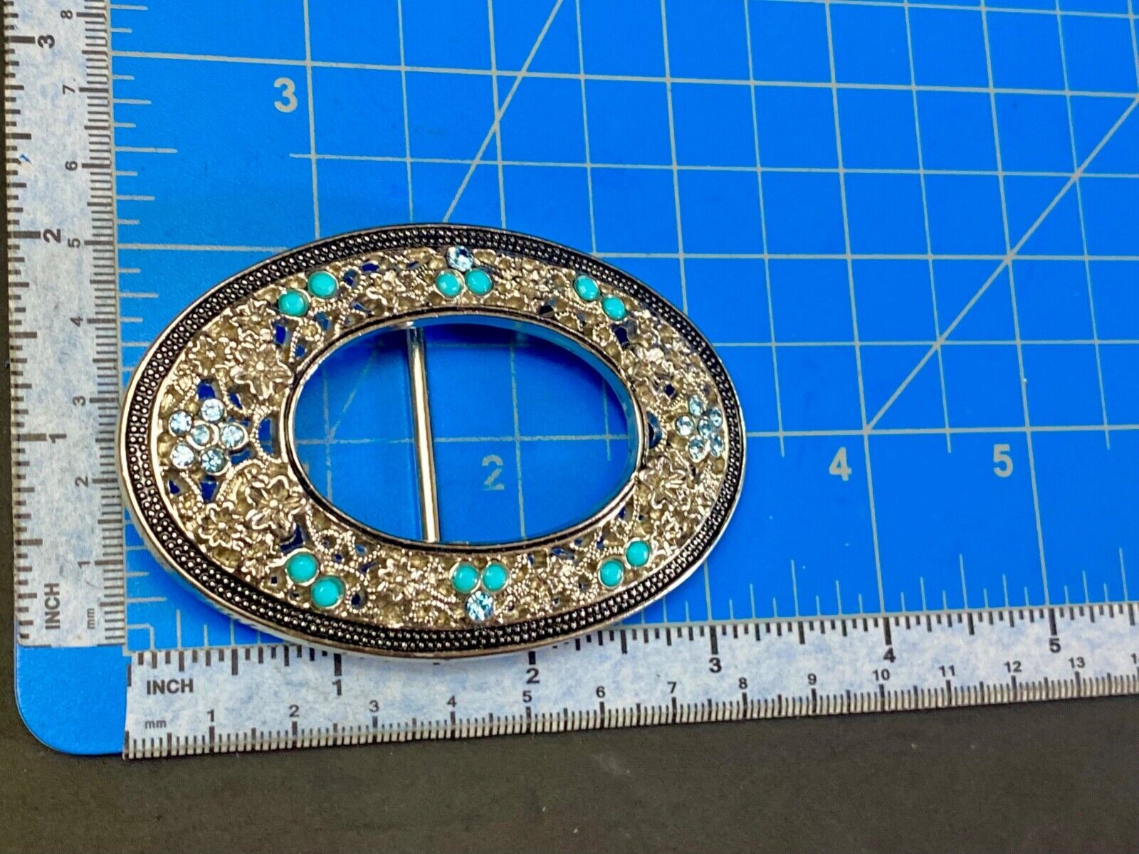 Unique blue rhinestone accented oval see though silver tone belt buckle