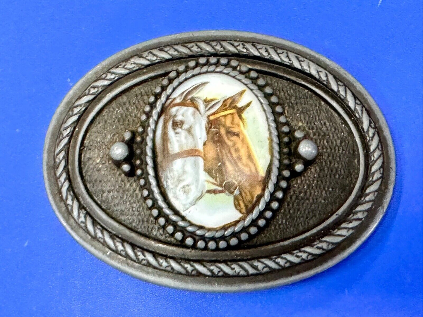 2 horses picture as centerpiece in western oval belt buckle with rope border