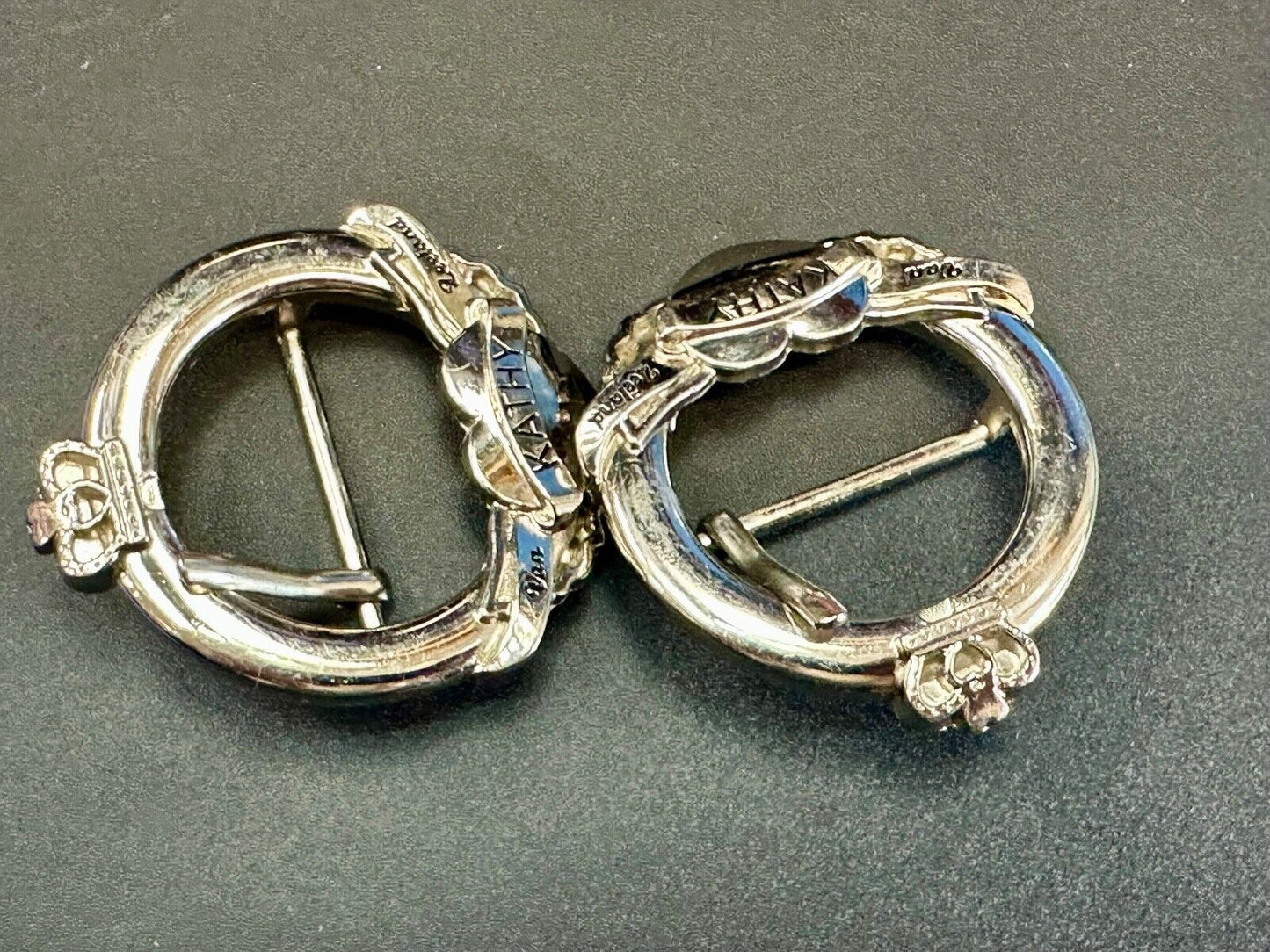 Two Kathy Van Zeeland signed silver tone round heart accented belt buckles