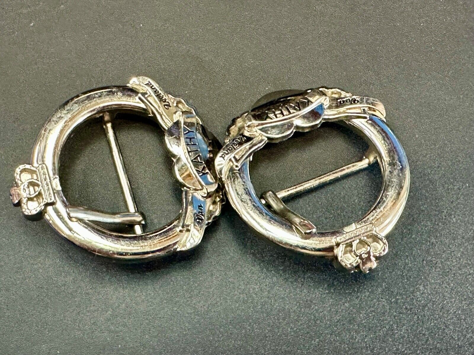 Two Kathy Van Zeeland signed silver tone round heart accented belt buckles