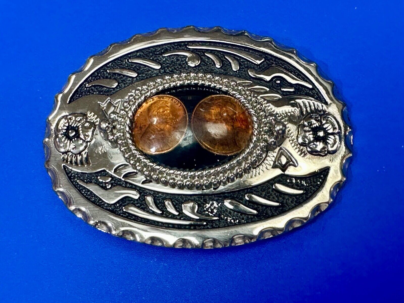 Two lucky pennies coins encased in cab style centerpiece of western belt buckle