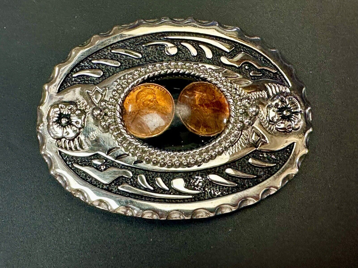 Two lucky pennies coins encased in cab style centerpiece of western belt buckle
