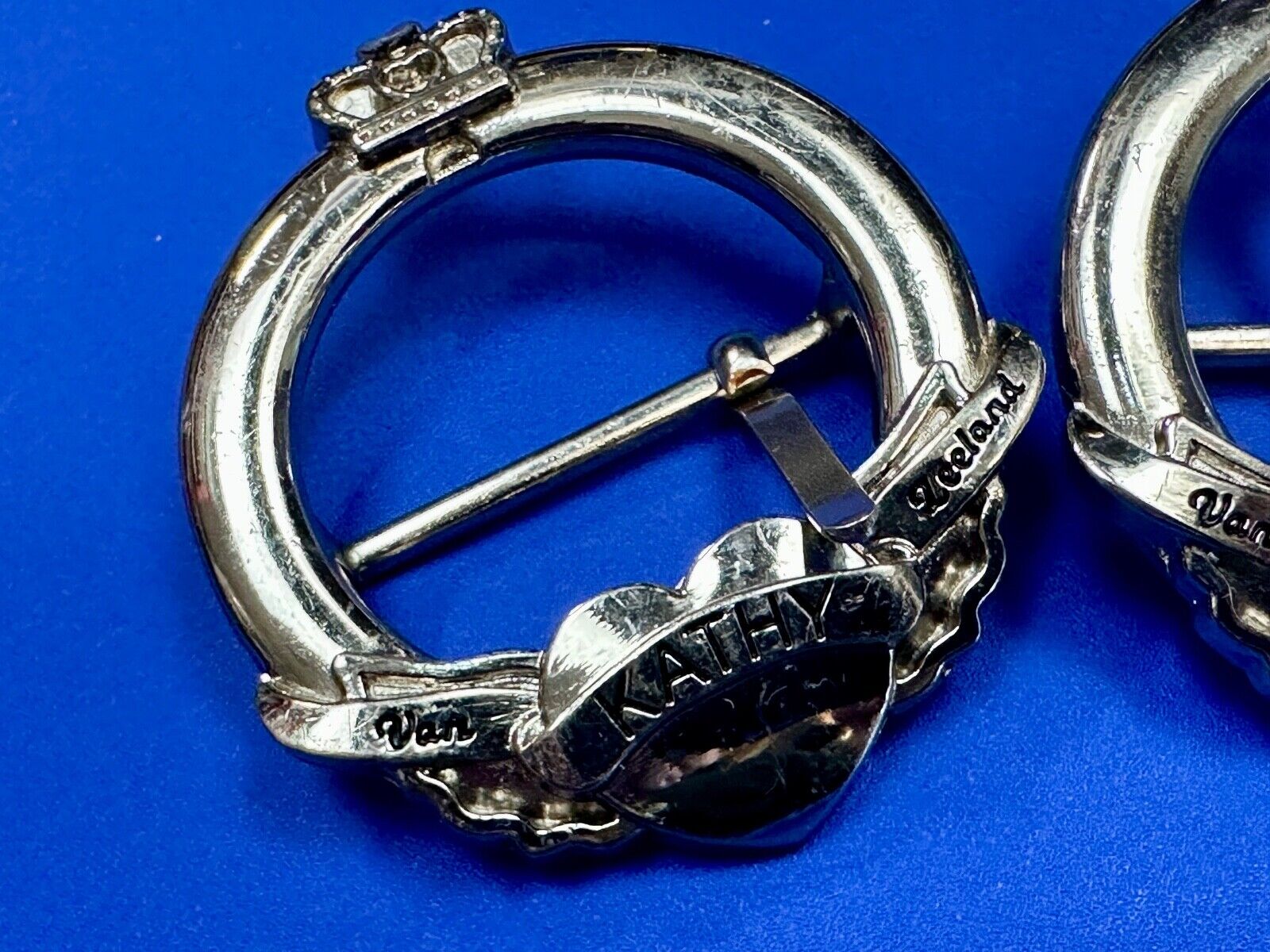 Two Kathy Van Zeeland signed silver tone round heart accented belt buckles